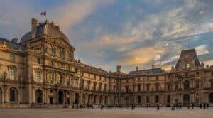 iew of famous Louvre Museum with Louvre Pyramid at evening