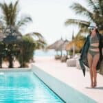 Woman relaxing by the pool in a luxury hotel resort enjoying perfect beach holiday vacation