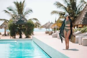 Woman relaxing by the pool in a luxury hotel resort enjoying perfect beach holiday vacation